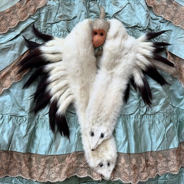 toy monkey wears a oversized mink stole